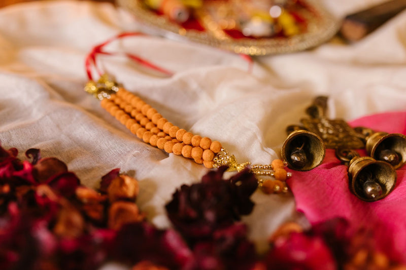 A naturally joined twin Gauri Shankar rudraksha bead resting on folded red silk